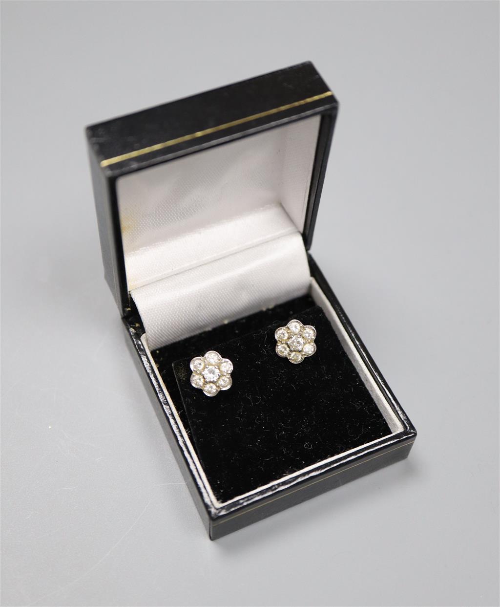 A pair of white metal and seven stone diamond set flower head cluster earrings, 8mm, gross 2.6 grams.